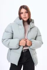 Campera puffer de corte holgado y diseño acolchado, con capucha integrada, cierre frontal y puños elásticos.