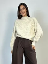 Sweater de punto con diseño amplio y mangas ranglan. Presenta cuello redondo tejido y puños acanalados, ofreciendo un calce cómodo y versátil.