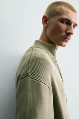 Chaqueta relaxed fit de tejido de punto de algodón, color verde militar, con cuello subido, manga larga, acabados en rib y cierre frontal con cremallera. Presenta efecto lavado.