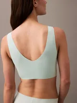 Bralette Calvin Klein color celeste, de microfibra sin costuras, con copas sin relleno y tirantes no ajustables.
