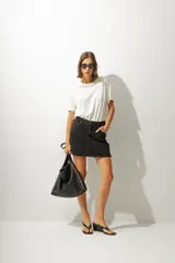 Minifalda de jean color negro con lavado gastado, corte recto y tiro alto.