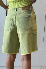 Bermuda de jean color marrón oscuro, tiro alto, con pinzas y ruedo desflecado.