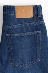 Jean de cinco bolsillos en denim de algodón lavado, modelo de tiro alto con piernas anchas y corte holgado.