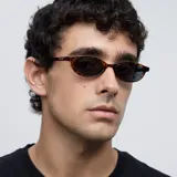 Gafas de sol con montura fina, estrecha y de forma ovalada con diseño carey. Lentes polarizadas color negro con protección UV400. Fabricadas con material Bio-based G850 y patillas de Propionato de Celulosa.