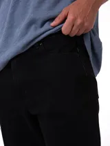 Jeans de corte slim color negro de la marca Caterpillar, con diseño clásico de cinco bolsillos, cierre de cremallera y botón metálico.