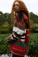 Campera de punto con cierre frontal, diseño de rayas horizontales multicolores y textura suave. Cuenta con cuello alto y mangas largas.