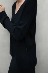 Sweater negro de tejido de punto con escote en V y mangas largas.