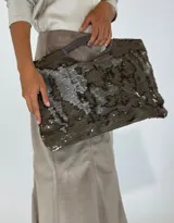 Bolso de mano tipo clutch color marrón con lentejuelas plateadas y manija rígida.