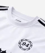 Remera de manga corta en tejido sintético color blanco, con cuello redondo y diseño de estilo deportivo. Presenta estampado frontal con lettering gótico y detalles laterales en tejido microperforado.