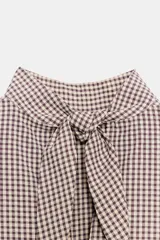 Camisa de manga corta con estampado de cuadros vichy, cuello subido y detalle de abertura en la espalda con lazada del mismo tejido.