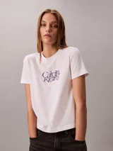 Remera blanca Calvin Klein de manga corta y cuello redondo, con estampado de logo script en el pecho en tono violeta.