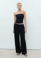 Pantalón de corte recto y tiro medio, confeccionado en mezcla de lino y viscosa. Presenta cintura elástica con cordón ajustable, dos bolsillos laterales y diseño largo.