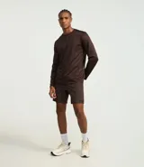 Remera deportiva de manga larga con cuello redondo, confeccionada en tejido técnico Dry Fit. Presenta un diseño liso en color negro con detalles reflectantes en los hombros.