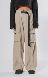 Pantalon cargo color vison de silueta oversize y pierna recta ancha. Cuenta con cintura elastizada, cinturón integrado con hebilla de seguridad, múltiples bolsillos laterales con solapa y detalles reflectivos.