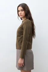 Chaqueta corta de simil gamuza color verde oliva, con cuello redondo y cierre frontal completo.