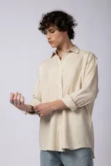 Camisa de manga larga confeccionada en lino, color verde oliva, con cuello clásico y cierre frontal de botones.