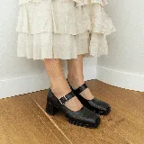 Zapato estilo Mary Jane de cuero vacuno con acabado brillante, punta cuadrada y taco bloque. Cuenta con una tira ajustable sobre el empeine con hebilla metálica.