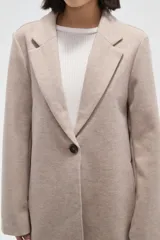 Tapado de corte recto con solapas clásicas y cierre frontal de un botón. Presenta mangas largas y bolsillos laterales integrados.