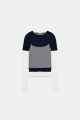 Camiseta de manga larga con diseño de efecto triple, combinando una capa superior de color azul marino, una capa intermedia de tirantes con estampado de rayas horizontales y una capa inferior blanca. Confeccionada en algodón con cuello redondo.
