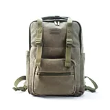 Mochila matera y porta notebook en tela canvas de color marrón, con diseño funcional que incluye bolsillo frontal con cierre, correas ajustables, manija superior y detalles de tiras de lona con hebillas metálicas.