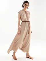 Mono largo color beige con cuello redondo, mangas cortas y cinturón trenzado a la cintura. Presenta aberturas laterales en las piernas y cierre con lazo en el cuello.