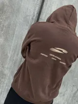 Canguro marrón con capucha ajustable con cordones y bolsillo tipo canguro.