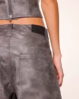 Pantalón de cuero sintético color gris con efecto desgastado, corte wide leg y tiro alto.