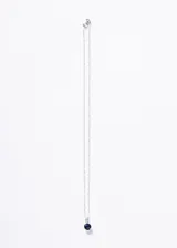 Collar de plata 925 con cadena tipo torsada y dije colgante. El dije consiste en una piedra central redonda de zirconia azul intenso, engastada en un soporte rectangular adornado con pequeñas piedras de zirconia transparentes.