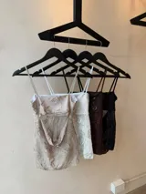 Top de tul color champagne con bordado de lentejuelas y diseño floral, tirantes finos, escote recto y abertura frontal pronunciada.