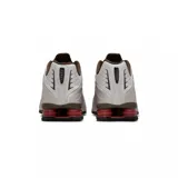 Championes Nike Shox R4, color negro y plateado, con diseño aerodinámico y sistema de amortiguación de columnas Shox en el talón.
