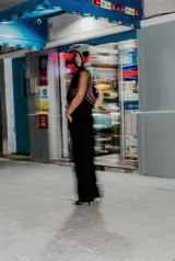 Chaleco negro de cuero con detalles de crochet en gris y rojo. Presenta un diseño sin mangas y un aplique de corazón bordado en el frente.