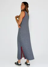 Vestido midi de punto con diseño a rayas verticales en tonos mostaza y blanco, con cuello redondo y sisas contrastadas en color bordó. Presenta aberturas laterales en el ruedo con detalles en color bordó.