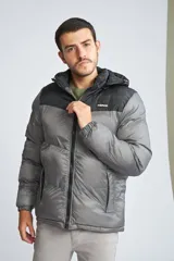 Campera puffer para hombre, color negro con canesú gris, capucha desmontable, cierre frontal con cremallera, bolsillos laterales con cierre y logo de la marca en el pecho.