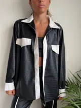 Camisa negra con estampado de piel de cocodrilo, detalles en blanco en cuello, solapa, bolsillos y puños.