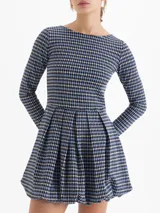 Vestido corto de punto con estampado de cuadros tipo príncipe de gales en tonos azul, negro y blanco. Presenta escote redondo, mangas largas y falda con diseño balloon que aporta volumen. Cuenta con espalda abierta con tiras cruzadas.