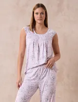 Conjunto de pijama marca René Rofé, compuesto por remera de mangas cortas con escote en V abotonado y pantalón capri con cintura elastizada. Diseño estampado con flores azules sobre fondo blanco.