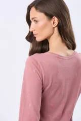 Remera de manga larga en color rosado, con cuello redondo y estampado sutil en tono sobre tono.