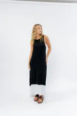 Vestido largo negro con base blanca, de corte suelto y sin mangas.