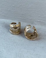 Anillo de diseño enlazado con textura irregular, realizado a mano en bronce. Presenta un diseño abierto que permite regular su tamaño con suavidad.