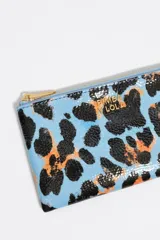 Monedero de tamaño grande con estructura rígida y exterior con textura brillante, estampado animal print en tonos rojo, negro y azul. Cuenta con cierre de cremallera dorado, logo metálico de Bimba y Lola y tarjetero interior.