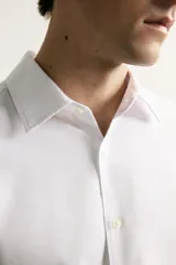 Camisa negra de corte regular fit, cuello italiano, manga larga con puño abotonado y cierre frontal con botones.