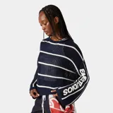Suéter de punto calado con perforaciones transpirables, de color azul marino con rayas horizontales blancas. Tiene diseño holgado, cuello redondo y mangas amplias con hombros caídos que incluyen el logo de la marca tejido en la manga.