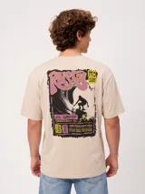 Remera de algodón color beige, de corte holgado y manga corta, con gran estampado en la espalda de estilo surf retro en tonos negros, rosados y amarillos de la marca Rusty.