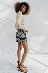 Falda pantalón corta de color azul marino con diseño bordado de flores en hilo crudo, forro interior y cierre lateral con cremallera oculta.
