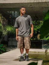 Remera de jersey color gris oscuro con efecto lavado, corte holgado y cuello redondo. Presenta un pequeño logo estampado en el pecho y un estampado grande en la espalda.