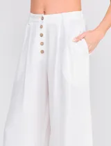 Pantalón palazzo color blanco, confeccionado en mezcla de lino y viscosa, de tiro alto con cierre frontal de botones, pinzas en la cintura y piernas anchas.