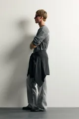 Jeans flare fit de denim de algodón en color gris con efecto lavado. Presentan diseño de cinco bolsillos, tiro medio y cierre frontal con cremallera y botón.