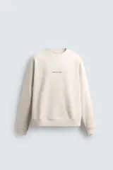 Sudadera de corte regular fit confeccionada en tejido de algodón con interior afelpado. Presenta cuello redondo, manga larga, acabados en rib y estampado de texto a contraste en el frente.