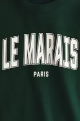 Buzo de cuello redondo con hombros caídos y diseño estampado frontal con la inscripción Le Marais Paris. Presenta puños y bajo acanalados.