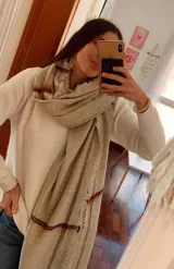 Bufanda de gran tamaño en color beige con diseño de cuadros sutiles en tono bordó y bordes deshilachados.